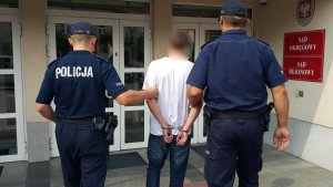 Policjanci prowadzą zatrzymanego.