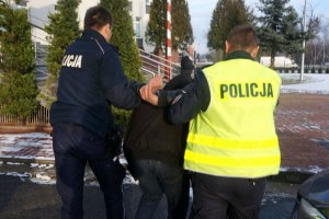 Policjanci prowadzą zatrzymanego.