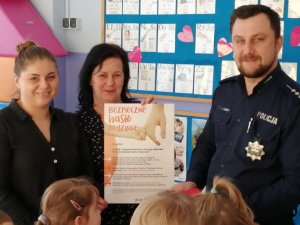 policjanci rozdają kolorowanki przedszkolakom
