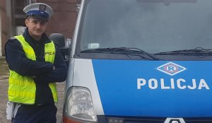 policjant stoi przy radiowozie