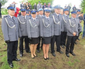 policjanci w mundurach galowych na cmentarzu w Kisielinie stoją w rzędzie podczas Mszy Świętej na cmentarzu - zdjęcie grupowe