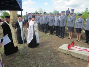 policjanci w mundurach galowych na cmentarzu w Kisielinie stoją w rzędzie podczas Mszy Świętej na cmentarzu - zdjęcie grupowe