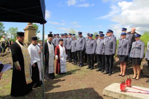 policjanci w mundurach galowych na cmentarzu w Kisielinie stoją w rzędzie podczas Mszy Świętej na cmentarzu - zdjęcie grupowe