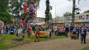 policjanci na motocyklach i radiowozem na festynie. w tle widać wiele osób uczestników festynu