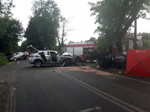 wypadek drogowy z udziałem 3 pojazdów - na zdjęciu pojazd marki BMW stoi na środku drogi, na prawo pojazd Opel, po lewej stronie w rowie pojazd marki VW