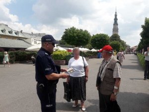 dzielnicowi wręczają ulotki seniorom w rejonie Jasnej Góry