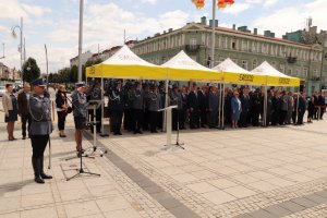 policjanci na Placu Biegańskiego podczas uroczystości oddają honor podczas hymnu