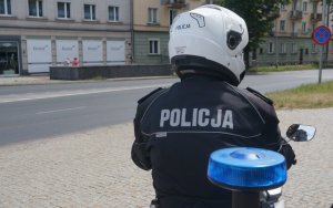 policjant na motocyklu - siedzi tyłem do fotografującego