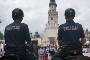 dwóch policjantów siedzących na koniach przodem do Jasnej Góry - tyłem do fotografującego