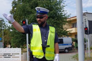 policjant w białej czapce i gwizdkiem kieruje ruchem