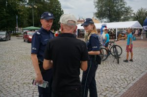 policjanci rozmawiają z osoba starszą o zagrożeniach oszustwami pod legendą