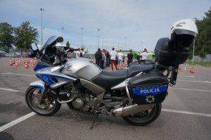 na pierwszym planie policyjny motocykl w tle tor przeszkód na placu manewrowym