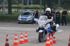 policjant na motorze, w tle policyjny radiowóz z policjantką