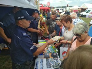 policjant wręczajacy ulotki obywatelom