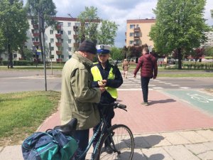 policjantka przed przejściem dla pieszych rozmawia z rowerzystą