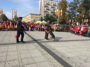 policjant z psem służbowym który atakuje pozoranta w tle grupa dzieci