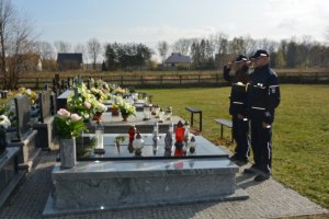 2 policjantów stoi nad grobem