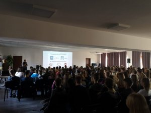 policjantka przed duzą grupą młodzieży na sali gimnastycznej