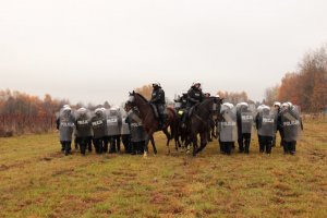 dwa rzędy podoodziału policji pomiedzy wychodzą konie policyjne z jeźdźcami