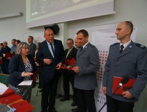 dwóch policjantów odbiera medal od mezczyzny