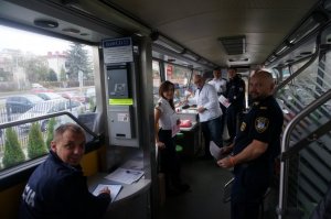 Policjanci i straznicy miejscy czekający wewnatrz krwiobusu w kolejce do oddania krwi, jeden policjant uzupełnia specjalna ankietę