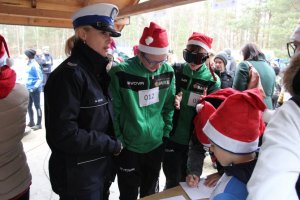 policjantka z dziećmi w czapkach mikołaja