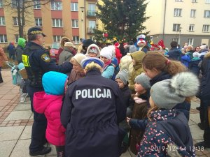 policjantka i strażnik miejski rozdają dzieciom opaski odblaskowe