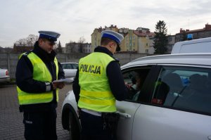 dwóch policjantów przy drzwiach kierowcy