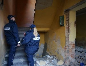 policjant z policjantką na schodach w pustostanie