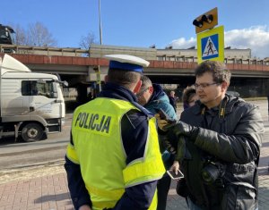 policjant przy ulicy rozmawia z dziennikarzami