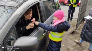 dziewczynka wręcza kierowcy lizaka w kształcie serca