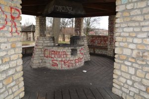 napisy typu graffiti naniesione czerwoną farba na elewacje różnych obiektów z kamienia we Mstowie