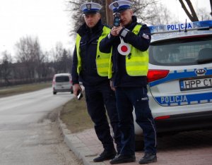 policjanci na drodze z ręcznym miernikiem prędkości