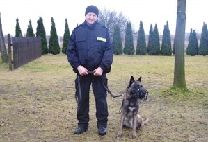 policjant szkoli psa służbowego w terenie