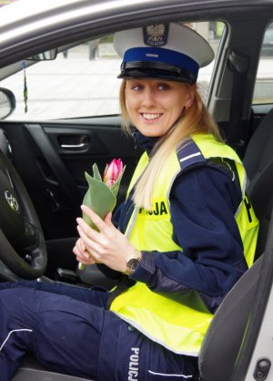 policjantka pozuje z kwiatkiem w radiowozie