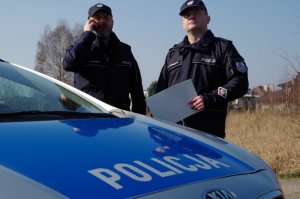 policjanci nawiązują kontakt z osoba poddaną kwarantannie przed jej mieszkaniem