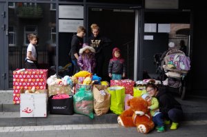 kilkoro dzieci pozuje do zdjęcia przy pudełkach z zabawkami