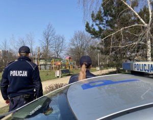 policjanci przy placu zabaw kontrolują stosowanie się obywateli do obowiązujących przepisów