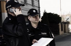 policjanci sprawdzają przed domem jednej z osób objętych kwarantanną czy jest w domu