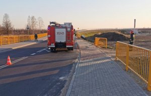 straż pożarna stoi na drodze, poza droga auto w rowie i uszkodzone barierki