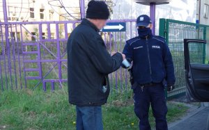 policjanci wręczają maseczkę mężczyźnie, który jej nie posiada