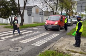 policjanci z ruchu drogowego w kamizelkach odblaskowych kontrolują samochody w pobliżu przejścia dla pieszych