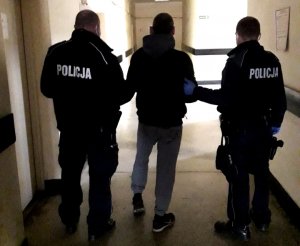 policjanci w mundurach prowadzą zatrzymanego