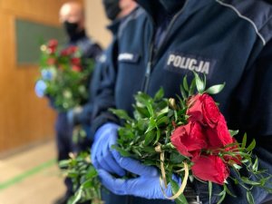 napis na mundurze policjanta &quot;POLICJA&quot; w tle czerwone róże