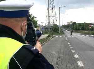 policjant przy drodze z ręcznym miernikiem prędkości