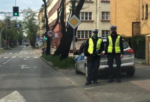 dwóch policjantów stoi przed skrzyżowaniem z przejściem dla pieszych