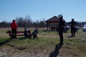 policjanci rozmawiają z obywatelami, którzy siedzą na ławce