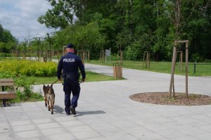 policjant z psem służbowym patroluje rejon kąpieliska wodnego