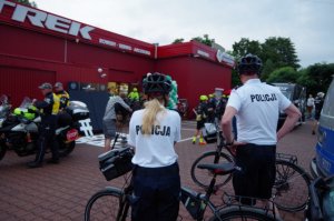 dwoje policjantów stoi przy rowerach służbowych pozując do zdjęcia