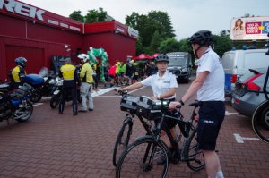 dwoje policjantów stoi przy rowerach służbowych pozując do zdjęcia